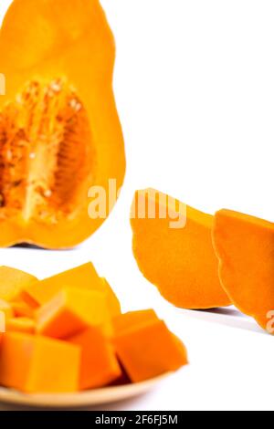 Fette di zucca dolce con cubetti su un piatto isolato su un bianco. Foto Stock