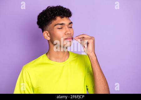 Foto di un giovane bell'uomo africano che mostra mani deliziose gustose perfetto segno ideale isolato su sfondo di colore viola Foto Stock