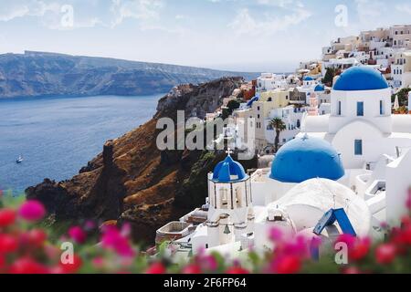 Cupole blu, campanile di chiese e fiori a Oia, Santorini, Grecia. Foto Stock