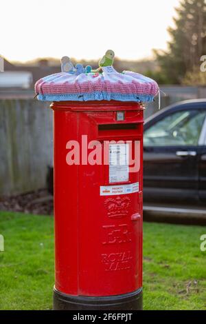 Bromsgrove, Worcs, Regno Unito. 31 Marzo 2021. Due caselle postali Royal Mail sono state improvvisamente misteriosamente decorate con graziose coperte a tema primaverile nella zona Catshill di Bromsgrove, Worcs. Le coperture graziose hanno pulcini, coniglietti e fiori che li adornano ed hanno un'etichetta calda e amichevole del messaggio fissata. Sembra che un gruppo Facebook di artigiani chochet chiamato Random atti di gentilezza crochet sono dietro il gesto. Altre caselle postali che sono state coperte allo stesso modo sono a Battersea, Lincoln e Galles. Credit: Peter Lopeman/Alamy Live News Foto Stock