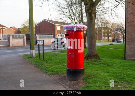 Bromsgrove, Worcs, Regno Unito. 31 Marzo 2021. Due caselle postali Royal Mail sono state improvvisamente misteriosamente decorate con graziose coperte a tema primaverile nella zona Catshill di Bromsgrove, Worcs. Le coperture graziose hanno pulcini, coniglietti e fiori che li adornano ed hanno un'etichetta calda e amichevole del messaggio fissata. Sembra che un gruppo Facebook di artigiani chochet chiamato Random atti di gentilezza crochet sono dietro il gesto. Altre caselle postali che sono state coperte allo stesso modo sono a Battersea, Lincoln e Galles. Credit: Peter Lopeman/Alamy Live News Foto Stock