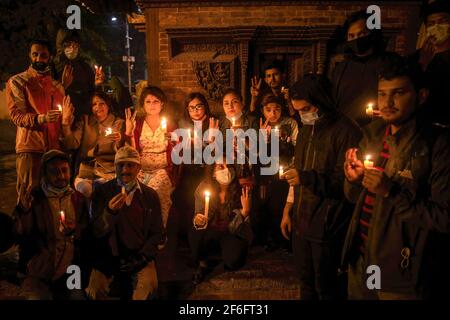 Kathmandu, Nepal. 31 Marzo 2021. I manifestanti che tengono candele bruciate mentre fanno il saluto a tre dita assiste a una veglia a lume di candela per coloro che sono morti in proteste durante il colpo di stato militare del Myanmar presso i locali di Basantapur Durbar Square, un sito patrimonio mondiale dell'UNESCO. Protesta contro il colpo di Stato militare e la violenza in atto in Myanmar. (Foto di Prabin Ranabhat/SOPA Images/Sipa USA) Credit: Sipa USA/Alamy Live News Foto Stock