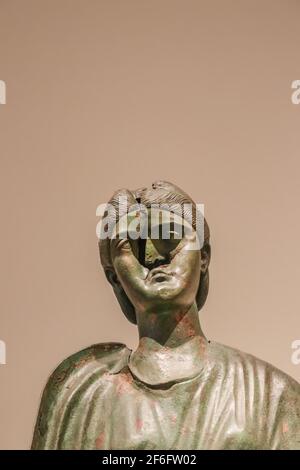 Antica scultura greca di ottone di donna con un scolpito dentro faccia su sfondo marrone - spazio per la copia Foto Stock