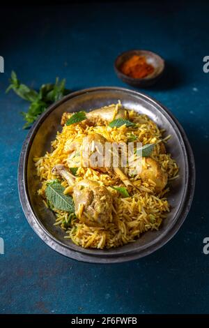 Cibo indiano o pakistano. Riso Biryani con erba di menta e pane naan su sfondo blu Foto Stock