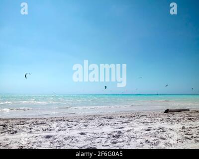 Kite surf sulla White Beach Rosignano Solvay con acque blu-caraibiche e sabbia bianca brillante in giornata di sole. Toscana, Italia Europa Foto Stock