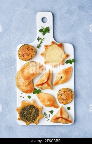 Pasticceria, fatayer o samosa, manaqeesh con zaatar e formaggio. Pasticceria assortita con spinaci e patate. Vista dall'alto Foto Stock