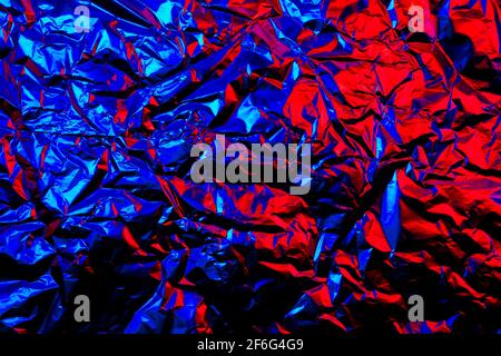 Astratto rosso e blu alluminio rugoso sfondo texture riflettenti luce rossa e blu Foto Stock