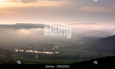 Aberystwyth, Ceredigion, Galles, Regno Unito. 31 marzo 2021 UK Meteo: Dopo una calda giornata di sole, la nebbia marina sorge dalla costa di Aberystwyth, che si diffonde nella valle del Rheidol mentre il sole tramonta dietro una nuvola bassa. © Ian Jones/Alamy Live News Foto Stock