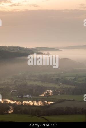 Aberystwyth, Ceredigion, Galles, Regno Unito. 31 marzo 2021 UK Meteo: Dopo una calda giornata di sole, la nebbia marina sorge dalla costa di Aberystwyth, che si diffonde nella valle del Rheidol mentre il sole tramonta dietro una nuvola bassa. © Ian Jones/Alamy Live News Foto Stock