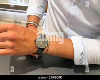 Alicante, Spagna - Marzo, 2021: Orologio nero high tech in ceramica e bracciale d'oro sul polso mans Foto Stock