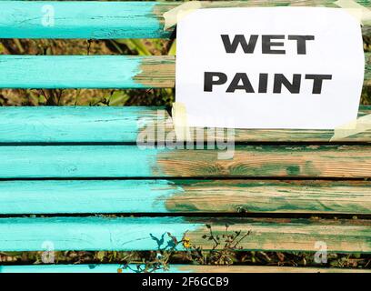 Cartello con vernice bagnata su un banco fresco verniciato Foto Stock
