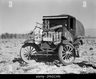 Auto dei rifugiati texani. Sono alla ricerca di lavoro nei campi di carote della Valle di Coachella. California. 1937. Fotografia di Dorotea Lange. Foto Stock