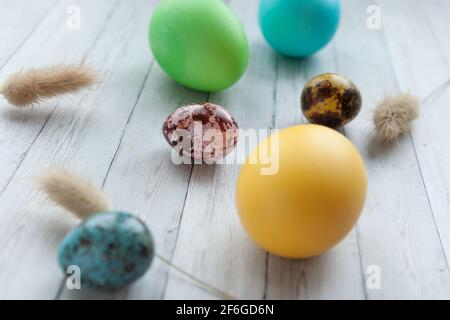 Uova di Pasqua colorate su uno sfondo di legno chiaro. Pasqua con uova colorate Foto Stock