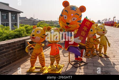 Xian, Cina - 30 aprile 2010: Mura della città di Huancheng. Closeup di colorful Year of the Tiger gonfiabili bambole come madre con 4 bambini in cima al bastione Foto Stock