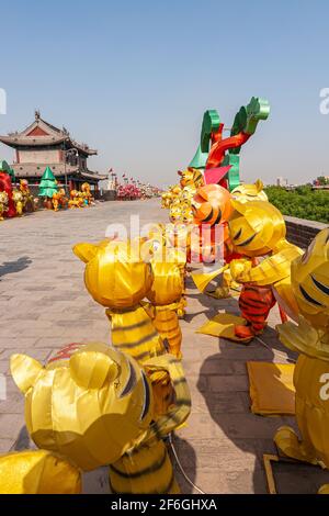 Xian, Cina - 30 aprile 2010: Mura della città di Huancheng. Closeup di colorful Year of the Tiger gonfiabili bambole per quanto l'occhio può vedere sul bastione sotto l Foto Stock