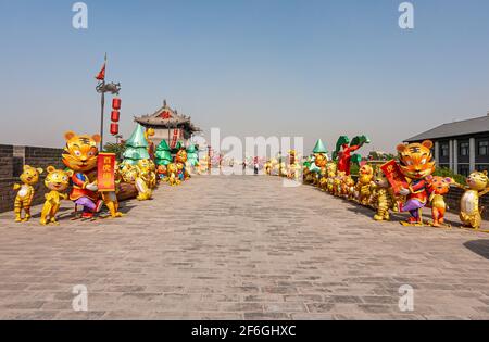 Xian, Cina - 30 aprile 2010: Mura della città di Huancheng. 2 file su ogni lato del bastione con anno delle bambole gonfiabili della tigre per quanto l'occhio può vedere li Foto Stock