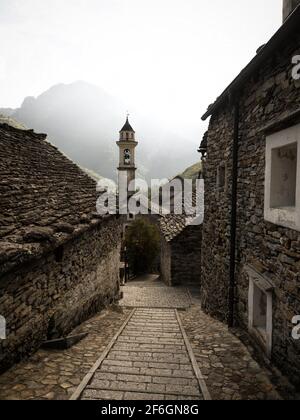 Vista panoramica del vecchio edificio storico in pietra scistosa tradizionale chiesa torre campanaria nel pittoresco e affascinante villaggio di Sonogno Verzasca V Foto Stock