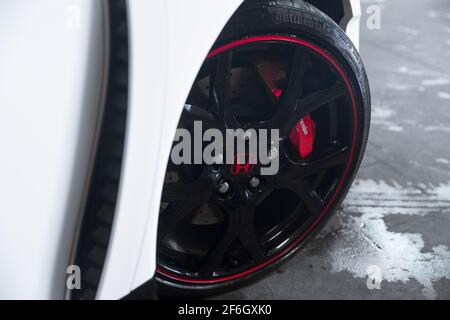 La ruota anteriore nera lucida su un Campionato Bianco 2016 Honda Civic Type R FK2 con pinze dei freni rosse Brembo Foto Stock