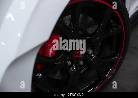 La ruota anteriore nera lucida su un Campionato Bianco 2016 Honda Civic Type R FK2 con pinze dei freni rosse Brembo Foto Stock