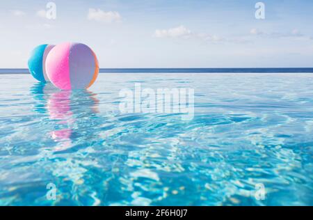 Palline da spiaggia galleggianti sull'acqua nella piscina a sfioro Foto Stock