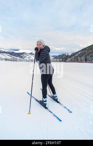 Stati Uniti, Idaho, Sun Valley, Senior woman cross - sci di campagna su piste battute Foto Stock