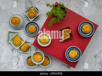 Un tradizionale pasticceria asiatica o Tao Sor su un tavolo di marmo. Dolce cinese farcito con pasta di fagioli mungo, taro, e uovo salato, uno dei più popolari snack in Foto Stock