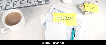 Banner con ora fiscale - notifica della necessità di archiviare dichiarazioni fiscali, modulo fiscale sul posto di lavoro del contabile. Vista dall'alto di blocco note, adesivi, tazza di caffè e. Foto Stock