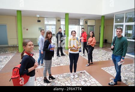 gli studenti si trovano nel corridoio della scuola presso un distanza dovuta alla pandemia del virus corona Foto Stock