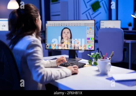 Creator creativo che ritocco ritratto usando il grado di colore a tarda notte in ufficio di editing professionale. Editor grafico che ritoccano le foto di un client su pc ad alte prestazioni prima della scadenza Foto Stock