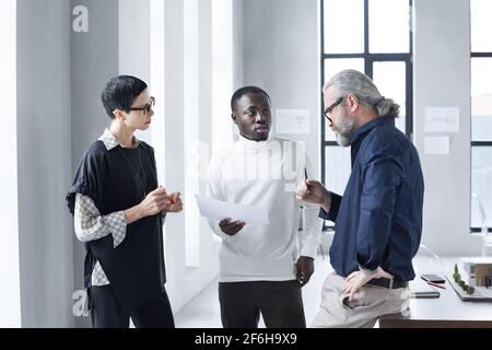 Gli uomini d'affari discutono dei momenti di lavoro mentre lavorano in squadra a. ufficio Foto Stock
