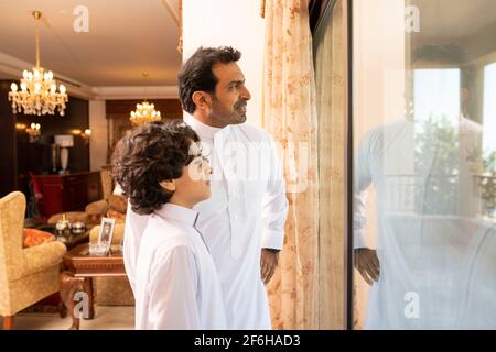 Padre e figlio arabi che parlano a casa Foto Stock