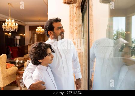 Padre e figlio arabi che parlano a casa Foto Stock