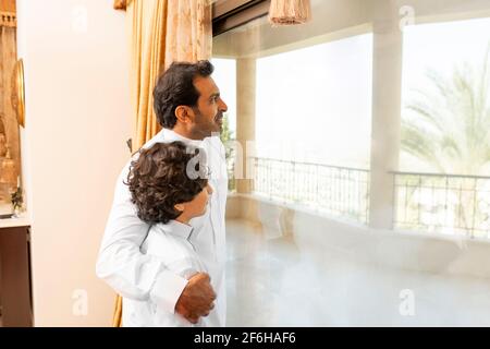 Padre e figlio arabi che parlano a casa Foto Stock