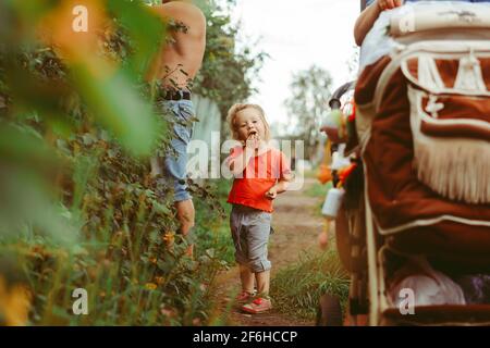 Bambina di mangiare le uve secche di Corinto nel giardino estivo Foto Stock