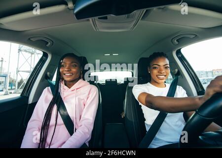 Giovani amiche africane che si divertono a guidare nel traffico cittadino Foto Stock