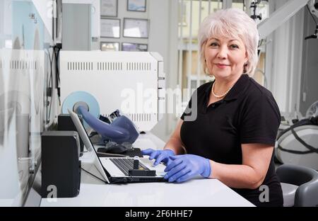 Ritratto di dottore femminile seduto al computer in clinica odontoiatrica Foto Stock