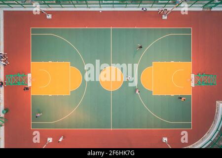 Vista dall'alto del campo pubblico di pallacanestro di Hong Kong, bambini che giocano all'aperto Foto Stock