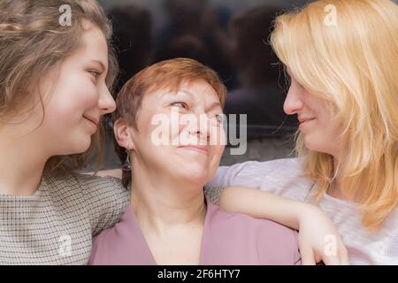 Una giovane ragazza si congratula con sua madre per la vacanza. Abbracci dolcemente e sorride. Foto Stock