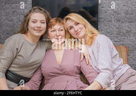 Una giovane ragazza si congratula con sua madre per la vacanza. Abbracci dolcemente e sorride. Foto Stock