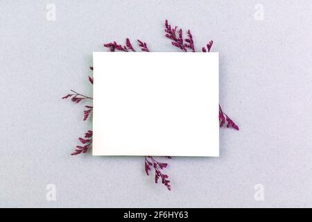 Creativo mockup di fiori con carta di invito vuota, concetto di sfondo piatto, con spazio di copia Foto Stock