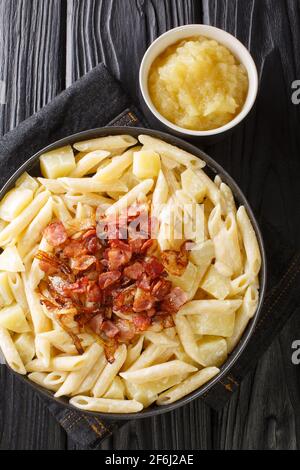 Macaroni svizzeri e formaggio con closeup di applausi Alplermagronen nel piatto sul tavolo. Vista dall'alto verticale Foto Stock