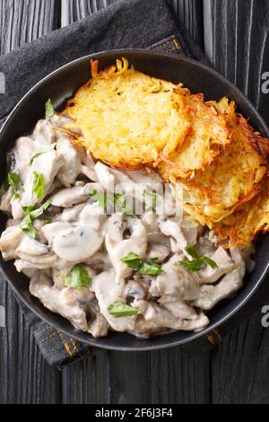 Zurcher Geschnetzeltes fatto di strisce di vitello a fette, vino bianco, funghi, panna e merletto servito con rosti in primo piano sul piatto. Ve Foto Stock