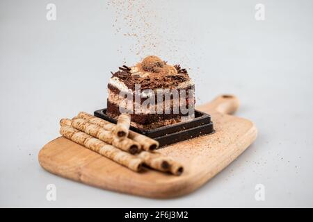 Torta della foresta nera decorata con panna montata e ciliegie. Isolato su sfondo bianco Foto Stock