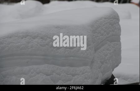 pezzo rettangolare di neve che rivela strati di diversi tipi e pesi di strati di neve a seconda della quantità climatica di nevicate nel carico invernale di neve Foto Stock