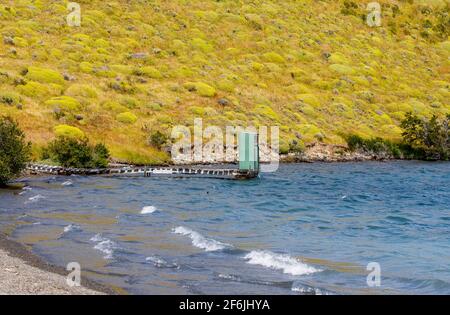 Verde lago servizi igienici esterni capannone in piedi alla fine di un molo di legno a Languna Azul, Torres del Paine National Park, Patagonia, Cile meridionale Foto Stock