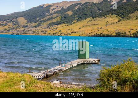 Verde lago servizi igienici esterni capannone in piedi alla fine di un molo di legno a Languna Azul, Torres del Paine National Park, Patagonia, Cile meridionale Foto Stock