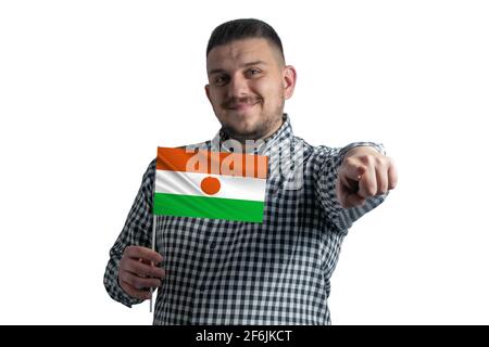 Ragazzo bianco che tiene una bandiera di Niger e punta in avanti di fronte a lui isolato su uno sfondo bianco. Foto Stock
