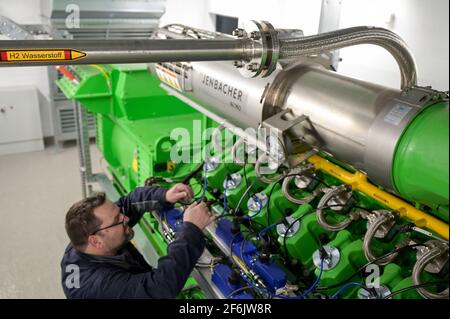 GERMANIA, Amburgo, un'unità di cogenerazione Megawatt per il riscaldamento e l'alimentazione con gas naturale o idrogeno verde, tubo H2 e generatore di motori a gas Jenbacher / DEUTSCHLAND, Amburgo, Hansewerk Natur, BHKW Blockheizkraftwerk 1 MW Klasse, das über Kraft-Wärme-Kopg suneine Siedlung mit Strom und Wärme versorgt, Energiequellen Erdgas oder Grüner Wasserstoff gewonnen aus erneuerbarer Energie, Wasserstoff Zuleitung fuer Jenbacher Gasmotor, der wahlweise grünen Wasserstoff oder Erdgas verbrennen kann Foto Stock