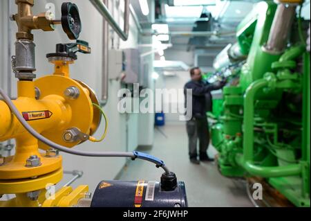 GERMANIA, Amburgo, un'unità di cogenerazione Megawatt per il riscaldamento e l'alimentazione con gas naturale o idrogeno verde, tubo H2 e generatore di motori a gas Jenbacher / DEUTSCHLAND, Amburgo, Hansewerk Natur, BHKW Blockheizkraftwerk 1 MW Klasse, das über Kraft-Wärme-Kopg suneine Siedlung mit Strom und Wärme versorgt, Energiequellen Erdgas oder Grüner Wasserstoff gewonnen aus erneuerbarer Energie, Wasserstoff Zuleitung fuer Jenbacher Gasmotor, der wahlweise grünen Wasserstoff oder Erdgas verbrennen kann Foto Stock