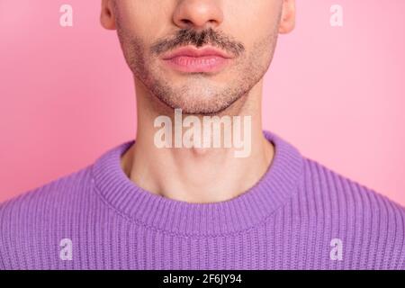 Vista del closeup dal taglio corto ritratto di un ragazzo dal design accattivante che si srade il mento isolato su sfondo color pastello rosa Foto Stock